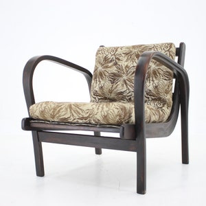 May include: A dark brown wooden armchair with curved arms and a beige and brown patterned fabric cushion.