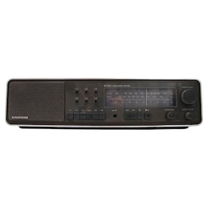Op de afbeelding: Een vintage Grundig RF 630 2-band radio in een donkerbruine en zilveren afwerking. De radio heeft een luidspreker, afstemknop en meerdere knoppen. De voorkant van de radio toont de zenderfrequenties en het Grundig logo.
