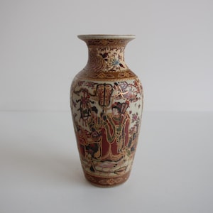 May include: A decorative, antique vase with a narrow neck and a wide base. The vase features a detailed, hand-painted design with figures in red, gold, and brown. The vase is approximately 6 inches tall.