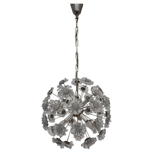 May include: A vintage chandelier with a spherical design, featuring numerous clear glass flower-shaped accents. The fixture hangs from a chain and has a metal canopy. The light bulbs are visible within the floral arrangement.