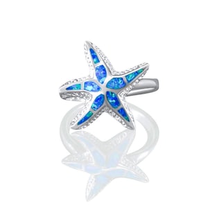 May include: A silver ring featuring a blue opal starfish design. The ring is displayed against a white backdrop.