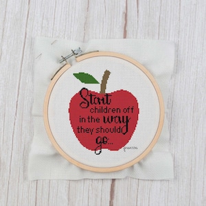 Może przedstawiać: Czerwone jabłko z zielonym liściem i szypułką, z tekstem "Start children off in the way they should go..." czarnymi literami.