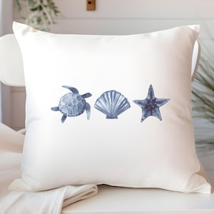 Peut inclure: Coussin carré blanc avec des illustrations à l'aquarelle d'une tortue de mer, d'un coquillage et d'une étoile de mer dans des tons bleus. Le coussin a un thème côtier ou nautique.