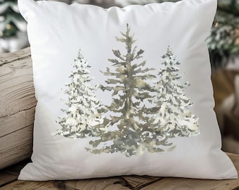 May include: White throw pillow with a watercolor design of three pine trees in shades of green and gray. The trees are covered in snow.