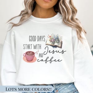 May include: White sweatshirt featuring the text "GOOD DAYS START WITH Jesus AND coffee." The design includes a pink coffee cup, an open book with flowers, and hearts. The bottom of the sweatshirt reads "LOTS MORE COLORS!!"