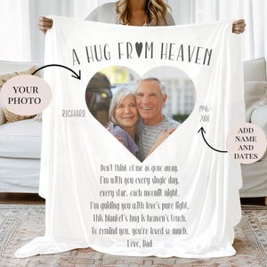 Może przedstawiać: Biały spersonalizowany koc z napisem "A HUG FROM HEAVEN" i ramką na zdjęcia w kształcie serca. Koc zawiera imię "Richard" i daty "1946-2008". Koc zawiera wiersz, który zaczyna się od słów "Nie myśl o mnie, że odszedłem..."