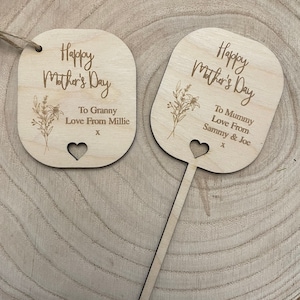 May include: Two wooden Mother's Day signs with floral designs and personalised messages. The top sign reads "Happy Mother's Day To Granny Love From Millie X". The bottom sign reads "Happy Mother's Day To Mummy Love From Sammy & Joe X".