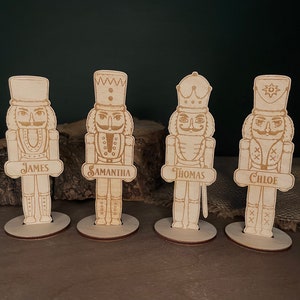 May include: Four wooden nutcracker place card holders with the names James, Samantha, Thomas, and Chloe.