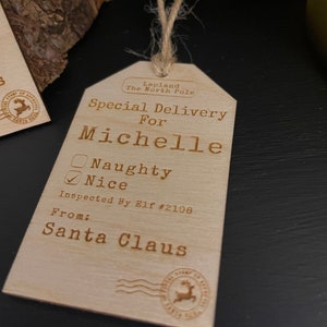 May include: A wooden Christmas gift tag with the text "Special Delivery for Michelle" and a checkbox marked "Nice". The tag also includes the text "Inspected By Elf #2108" and "From: Santa Claus".