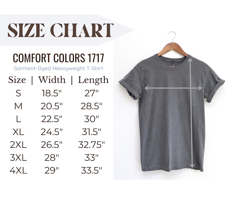 Puede incluir: Una camiseta gris Comfort Colors 1717 te&ntilde;ida en prenda de tejido pesado colgada de una percha de madera. La imagen incluye una tabla de tallas con medidas en cm: S (47cm ancho, 69cm largo), M (52cm ancho, 72cm largo), L (57cm ancho, 76cm largo), XL (62cm ancho, 80cm largo), 2XL (67cm ancho, 83cm largo), 3XL (71cm ancho, 84cm largo) y 4XL (74cm ancho, 85cm largo).