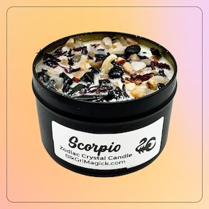 Puede incluir: Una vela en lata de metal negro cubierta con una mezcla de pequeños cristales pulidos, piedras oscuras y trozos de plantas secas. Una etiqueta blanca en el frente muestra el texto Scorpio, Zodiac Crystal Candle y BlkGrlMagick.com.