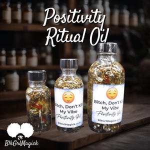Puede incluir: Tres botellas de vidrio llenas de hierbas y escamas doradas. Las botellas están etiquetadas con "Positivity Ritual Oil" y "Bitch, Don't Kill My Vibe Positivity Oil".