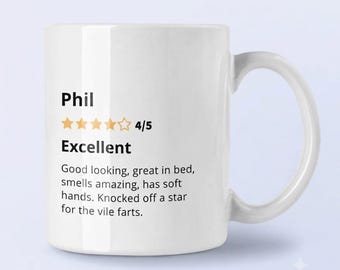 May include: A white ceramic mug featuring black printed text that reads Phil, 4/5, Excellent, and a review stating: Good looking, great in bed, smells amazing, has soft hands. Knocked off a star for the vile farts. The design includes four gold stars.