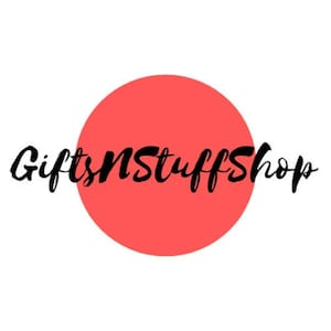 May include: A circular logo design featuring a solid coral-red circle centered on a white background. Overlaid across the center of the circle is the text GiftsNStuffShop written in a black, stylized, cursive script font that spans horizontally.