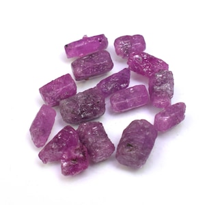 May include: A collection of pink ruby rough stones, each with a unique shape and texture. These raw gemstones are perfect for jewelry making or crystal healing.