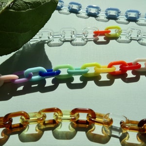 Puede incluir: Cuatro cadenas de plástico en diferentes colores: transparente, arcoíris, marrón y azul claro. Las cadenas están hechas de eslabones individuales que están conectados entre sí.