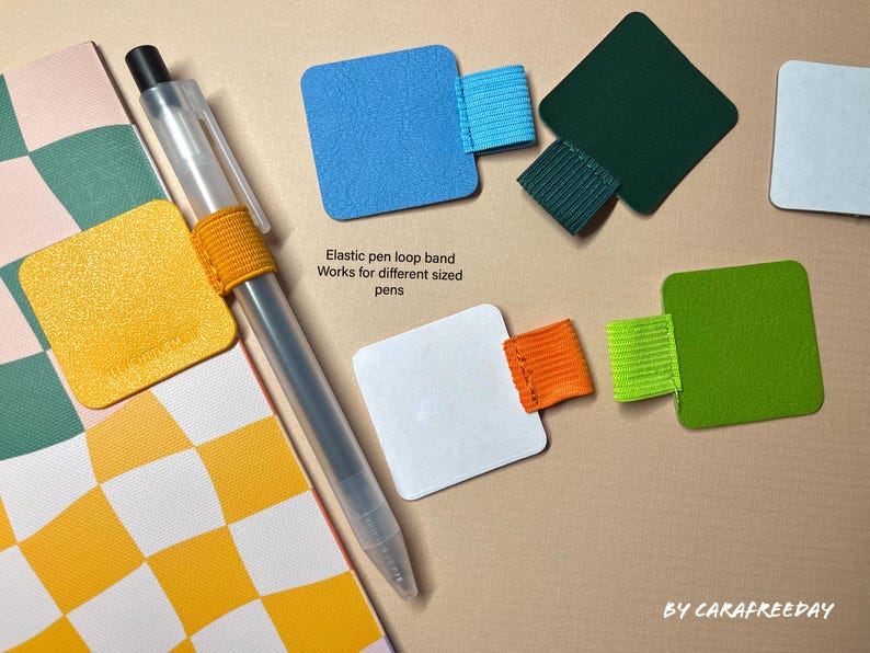 May include: A set of colorful pen loop bands made of elastic material. The bands are attached to square pieces of paper in various colors, including yellow, blue, white, green, and black. The text "Elastic pen loop band Works for different sized pens" is printed on the white paper.