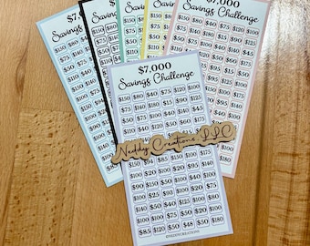 May include: A set of colorful stickers with different savings challenges. The stickers are printed with various amounts of money, ranging from $15 to $180. The stickers are designed to help people save money and reach their financial goals. The stickers are labeled "$7,000 Savings Challenge" and "Neddy Creations LLC".