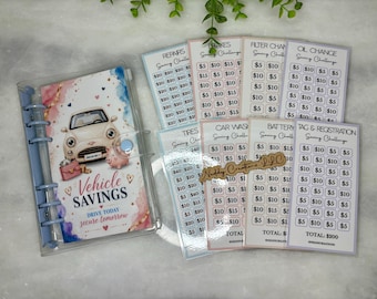 May include: A clear binder with a blue spine and a cover featuring a vintage car illustration, the words "Vehicle Savings", and savings challenge cards for car expenses. The cards include categories like repairs and oil changes.