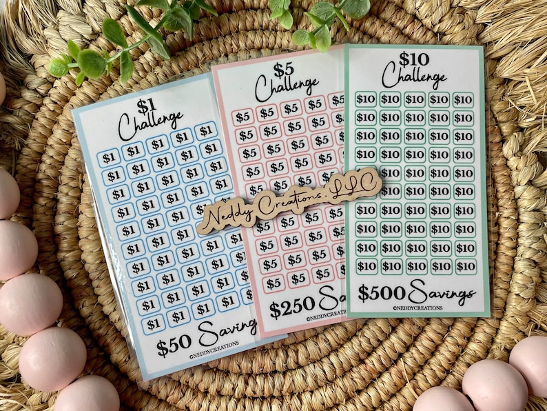 May include: Three sets of stickers for a savings challenge. The stickers are in blue, pink, and green. The blue stickers are for a $1 challenge, the pink stickers are for a $5 challenge, and the green stickers are for a $10 challenge. The stickers are labeled with the amount of money and the total amount of savings. The stickers are designed to help people save money.