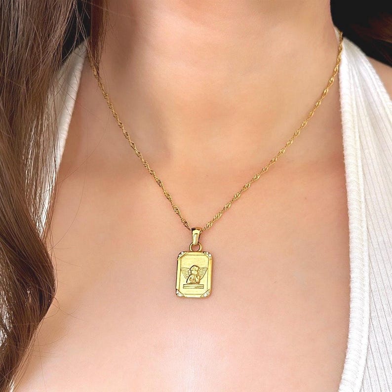 Dainty gold angel necklace worn on model showing 18k gold rectangular cherub pendant at collarbone length