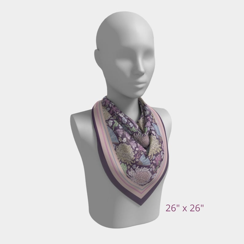 May include: A square scarf, 26 x 26 inches, draped on a mannequin. The scarf features a floral pattern in shades of purple, pink, and green, with a dark purple border and striped edges. The overall design is elegant and decorative.