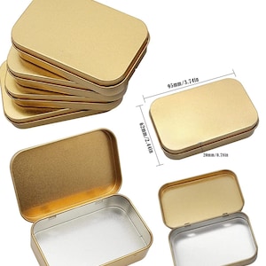 May include: Set of five gold metal rectangular tins with lids. Each tin measures 9.5cm long by 6.2cm wide by 2cm high.