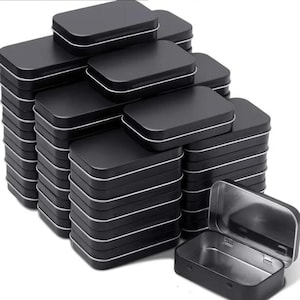 May include: A stack of 30 black metal tins with a single tin open to show the inside. The tins are rectangular and have a silver rim.