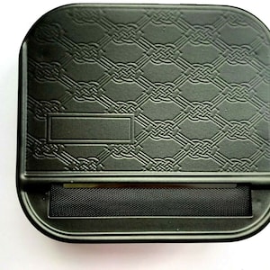 May include: Black rolling tray with a Celtic knot design and a rectangular slot for rolling papers.