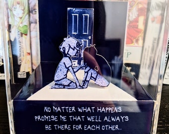 May include: A clear acrylic box with a black base and a white platform inside. The platform has a papercraft scene of two figures standing in front of a closed door. The text on the base reads "No matter what happens promise me that we'll always be there for each other..."