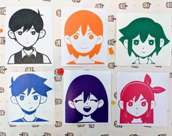 May include: Six square stickers featuring stylized anime-style character portraits in various colors: black, orange, green, blue, purple, and red. Each sticker has a white background and a unique character design.