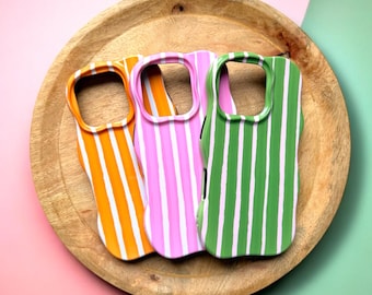 May include: Three phone cases with striped designs. The cases are orange and white, pink and white, and green and white.