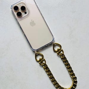 Coque téléphone transparente avec dragonne chaîne dorée – Maillons aluminium et attaches cœur – Accessoire chic et tendance