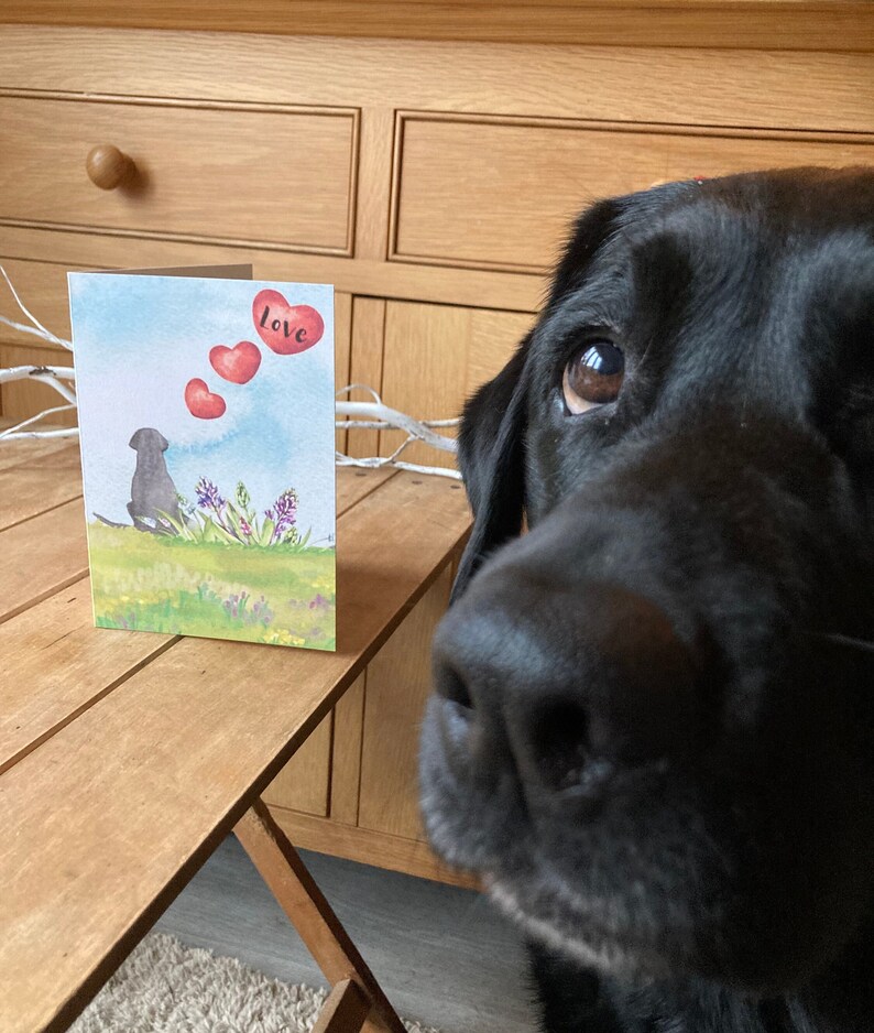 May include: A watercolor card with a black dog silhouette and red hearts floating above it. The card says "love" on the top right corner.