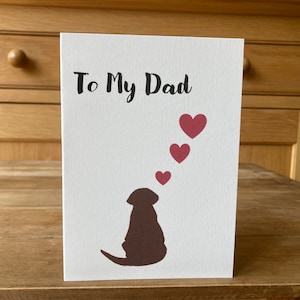 Pode incluir: Um cart&atilde;o branco com o texto "To My Dad" em letras pretas. Uma silhueta marrom de um cachorro est&aacute; na parte inferior do cart&atilde;o, olhando para cima para tr&ecirc;s cora&ccedil;&otilde;es rosa.
