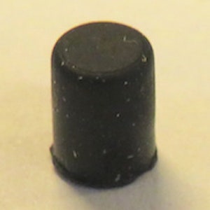 May include: A black rubber bottle stopper.