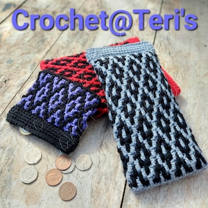 May include: Three crocheted coin purses in different color combinations. The purses are made with black, red, purple, and gray yarn. The purses are lying on a wooden surface.