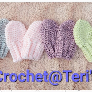 May include: Four pairs of crocheted baby mittens in grey, pink, purple, and green. The mittens are laid out on a fluffy, light brown surface. The text "Crochet@Teri's" is at the bottom of the image.