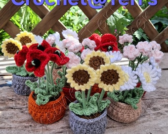 Op de afbeelding: Een verzameling gehaakte bloemen in kleine potten. De bloemen zijn rode klaprozen, gele zonnebloemen en witte madeliefjes. De potten zijn in verschillende kleuren, waaronder oranje, grijs en beige. De tekst "Crochet@Teri's" is zichtbaar.