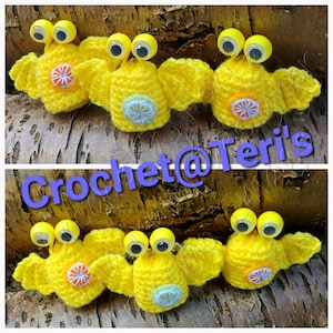 May include: Five crocheted yellow amigurumi with googly eyes and colorful flower accents. Crochet@Teri's is written on the image.