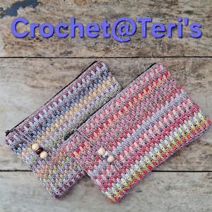 May include: Two handmade crochet zipper pouches in shades of pink, purple, yellow, and blue. Each pouch features a beaded accent and the text "Crochet@Teri's" in purple. The pouches are displayed on a wooden surface.