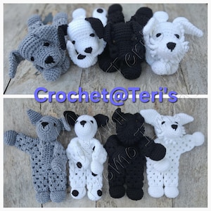 May include: Four crocheted dog plushies in different colors: gray, black and white, black, and white. The plushies are lying down with their heads facing the camera. The plushies are all about 6 inches long. The plushies are on a wooden surface. The text "Crochet@Teri's" is visible in the image.