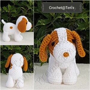May include: A crocheted white dog with brown ears and a brown nose. The dog is standing on a white surface. The text "Crochet@Teri's" is visible in the background.