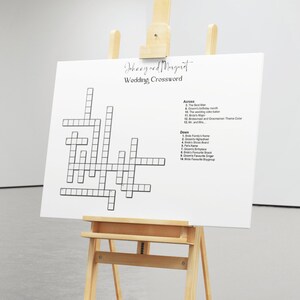 Op de afbeelding: Een zwart-witte bruiloft-kruiswoordpuzzel op een wit ezel. De kruiswoordpuzzel heeft bovenaan de namen "Johnny en Margaret" en bevat aanwijzingen voor de bruid en de bruidegom.