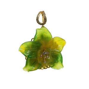 Può includere: Un ciondolo d'oro con un fiore di giglio verde e giallo con un accento di diamante al centro.