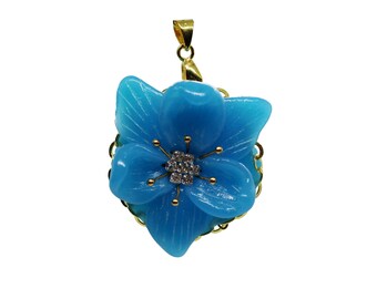Könnte beinhalten: Ein blauer Blumenanhänger mit einer goldenen Fassung und einem klaren Kristall in der Mitte. Der Anhänger ist ein zartes und feminines Schmuckstück.