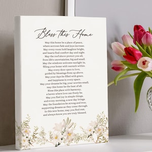 May include: A white canvas print with a floral design and a poem about home. The poem reads "Bless this Home" and includes phrases like "a place of peace", "laughter bright", and "a haven where love can freely be".
