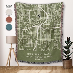 May include: A green woven throw blanket with a white map of a city and the text "OUR FIRST DATE 33° 45' 19.998", -84° 23' 20.832" 27 JUL 2019".
