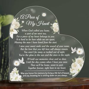 May include: A heart-shaped clear acrylic memorial plaque featuring white floral illustrations and a dove. The text reads: A Piece of My Heart, When God called you home, a part of me went too, for a piece of my heart belongs to you.