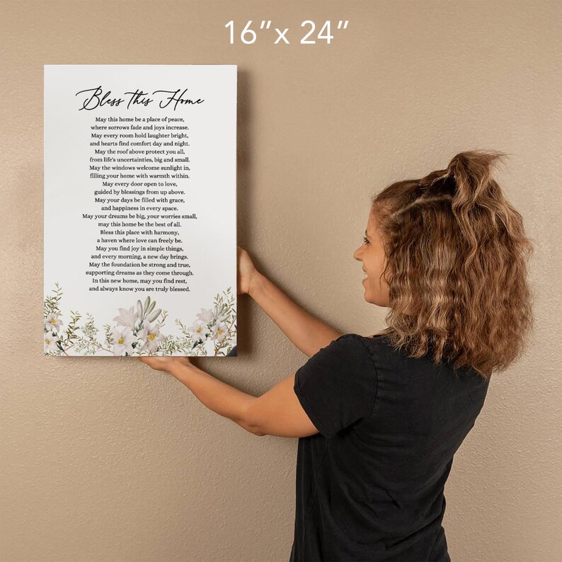 Puede incluir: Una impresi&oacute;n en lienzo blanco con un dise&ntilde;o floral y un poema que dice "Bless this Home". El poema trata sobre encontrar la paz, la alegr&iacute;a y el amor en un hogar. La impresi&oacute;n mide 16 pulgadas por 24 pulgadas.